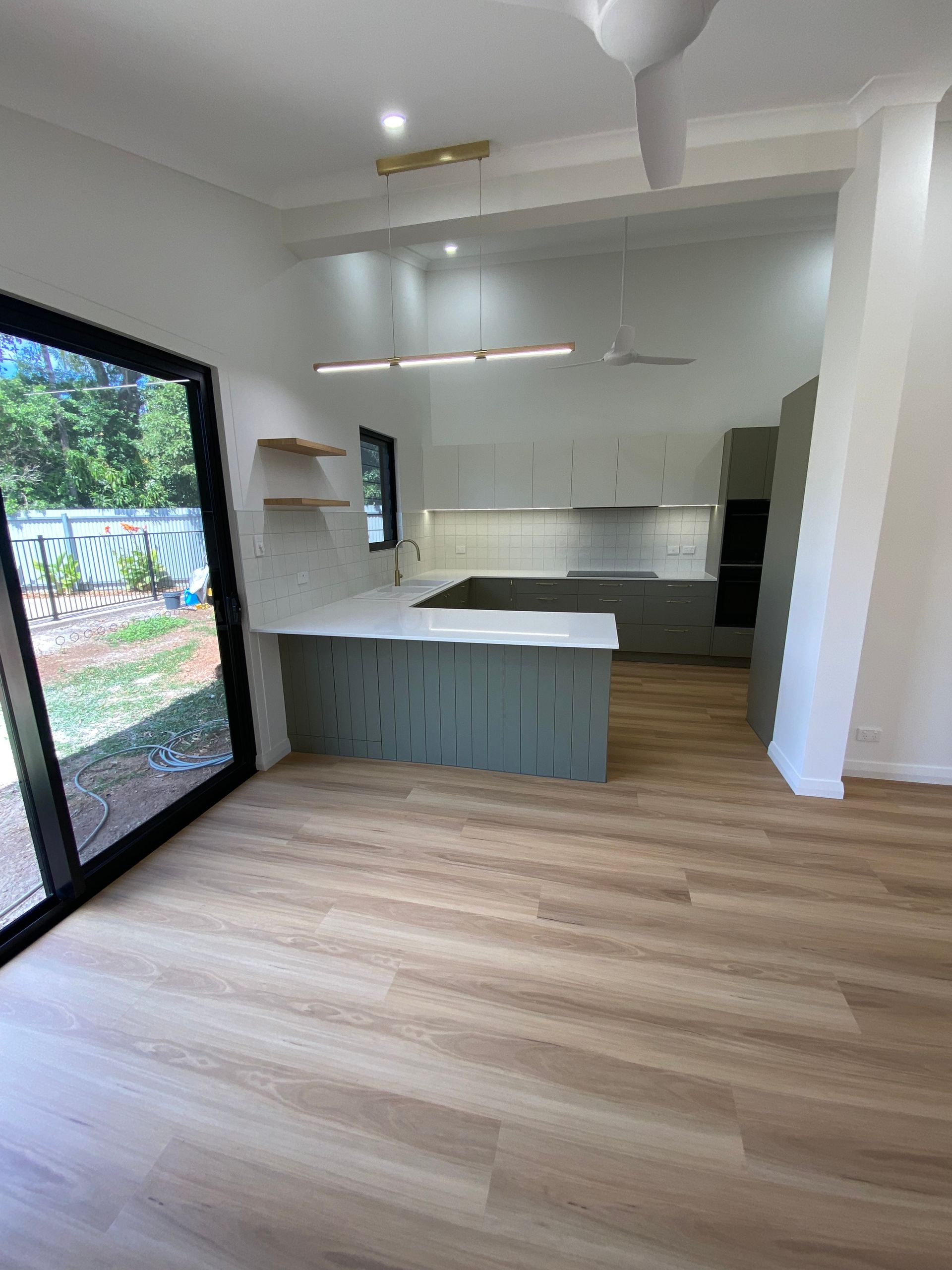 A Kitchen With White Cabinets, a Sink, and a Flat Screen TV — New Home Builders in Yarrawonga, NT