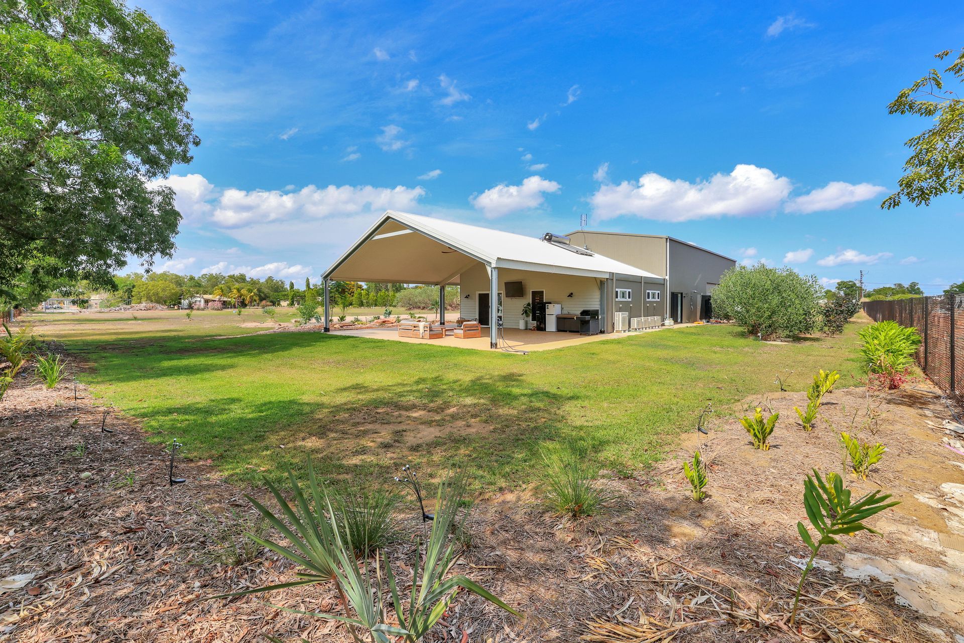 A Kitchen With White Cabinets and Stools and a Ceiling Fan — New Home Builders in Yarrawonga, NT