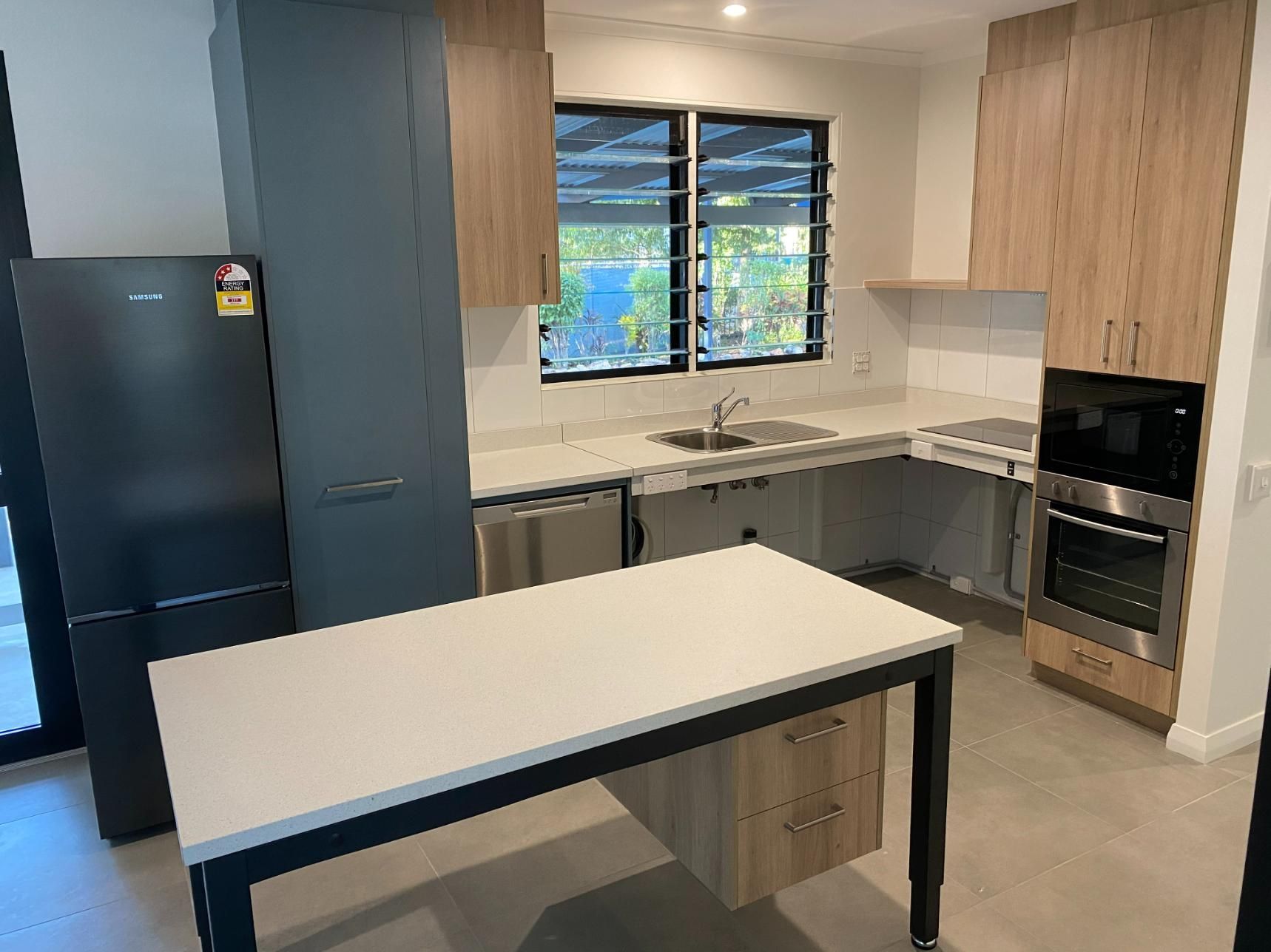 A Kitchen With a Table in the Middle of It and a Refrigerator — NDIS Home Modifications in Yarrawonga, NT