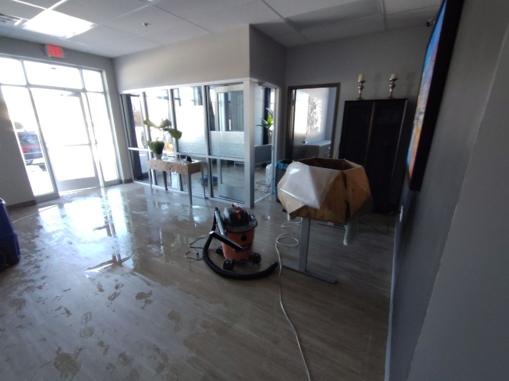 A vacuum cleaner is sitting in a room with a lot of windows.
