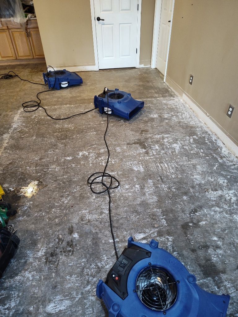 Two blue fans are sitting on the floor of a room.