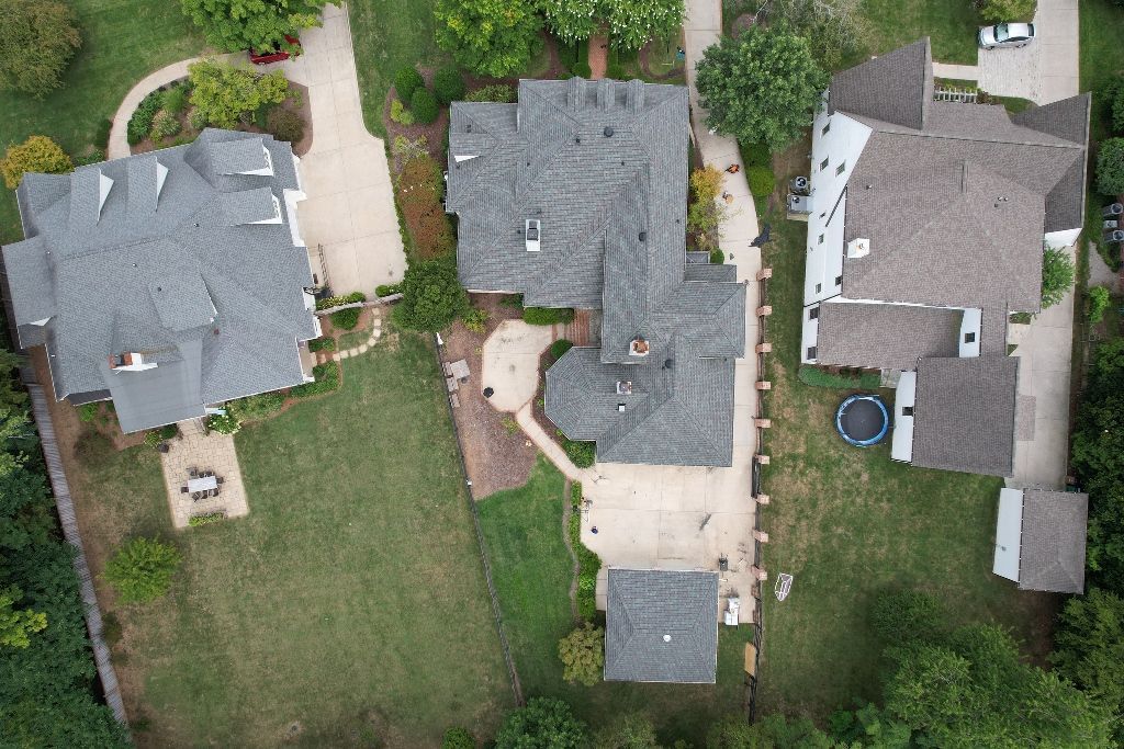 An aerial view of a residential area with a lot of houses and trees.