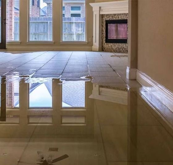A living room with a flooded floor and a fireplace.