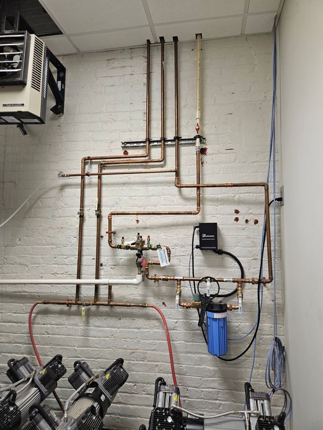 A room with a lot of pipes hanging on the wall.