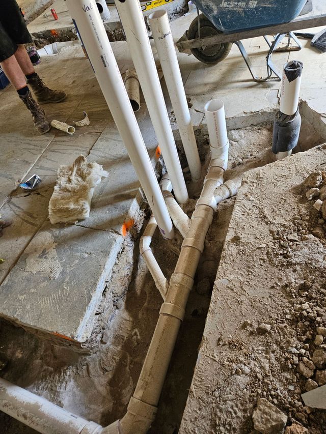 A bunch of pipes are being installed in a hole in the ground.