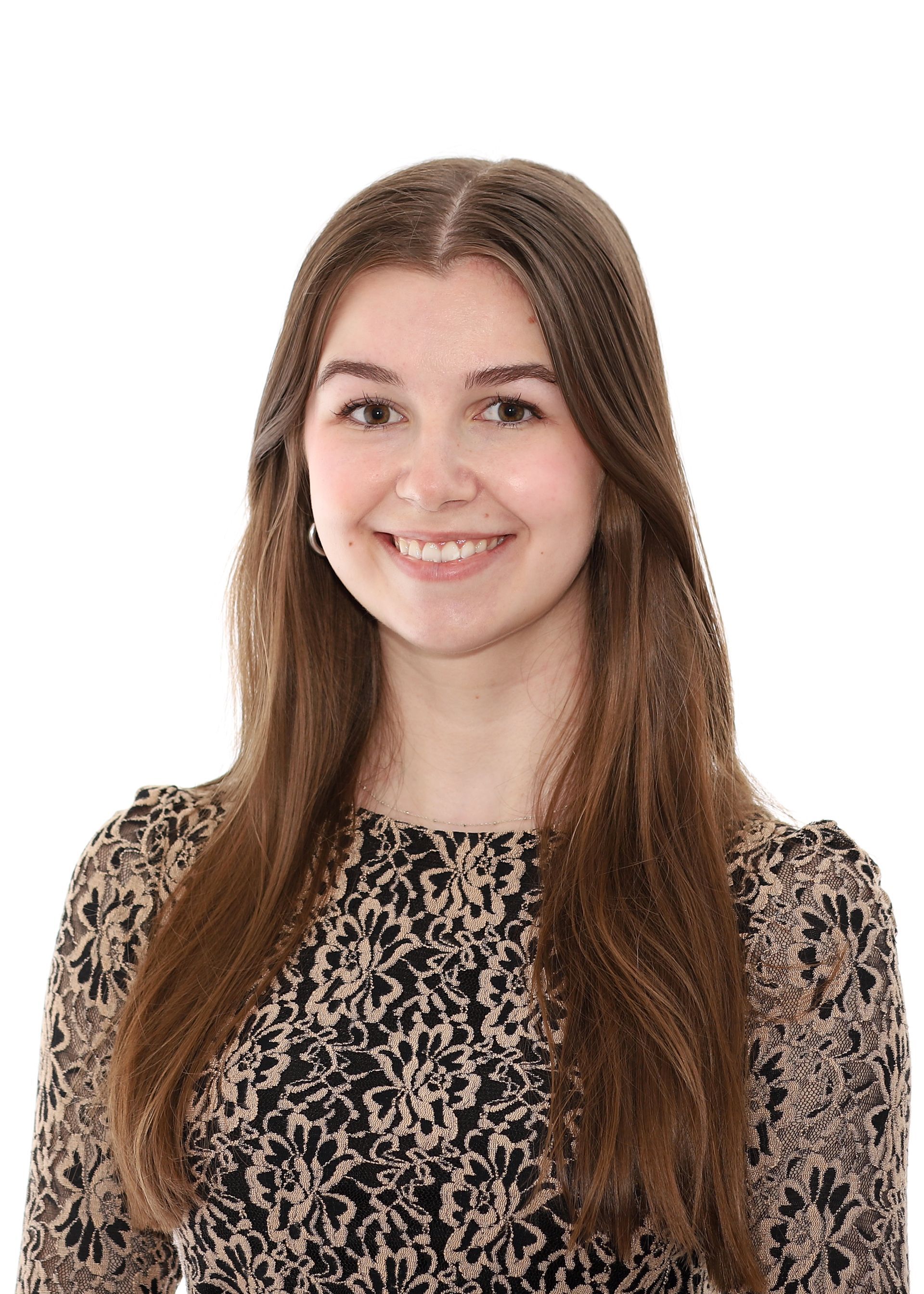 Une jeune femme vêtue d'une robe à imprimé léopard sourit à la caméra.