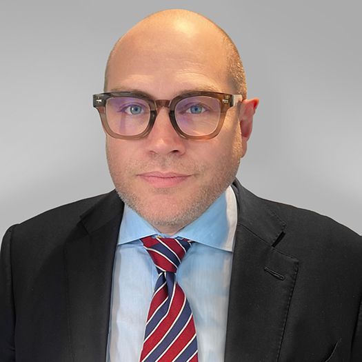 A man wearing glasses and a suit and tie.