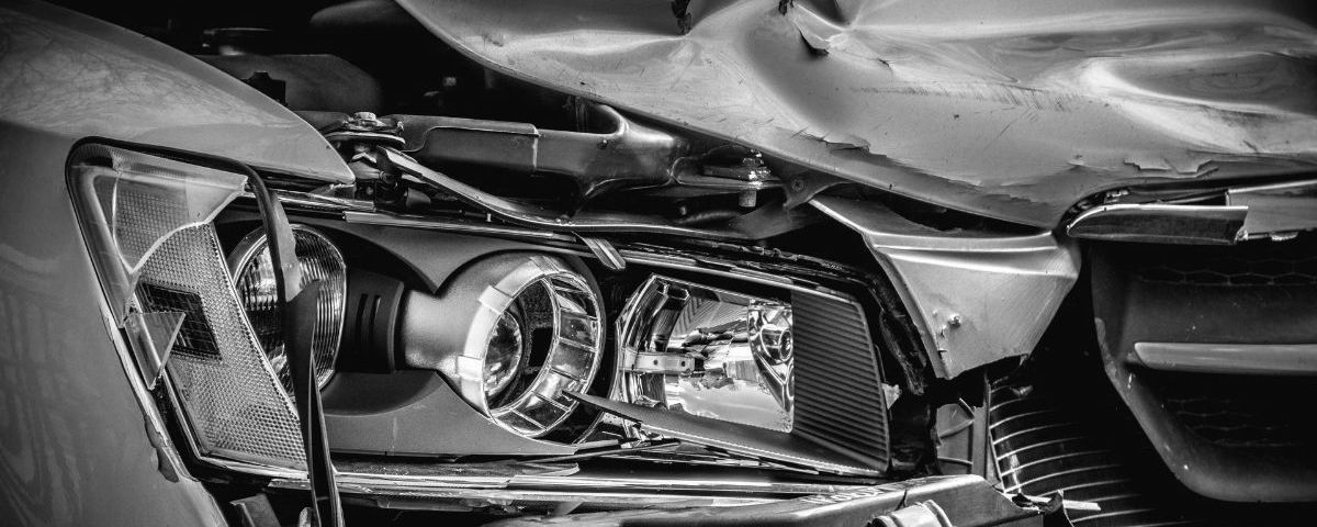 A black and white photo of a damaged car.