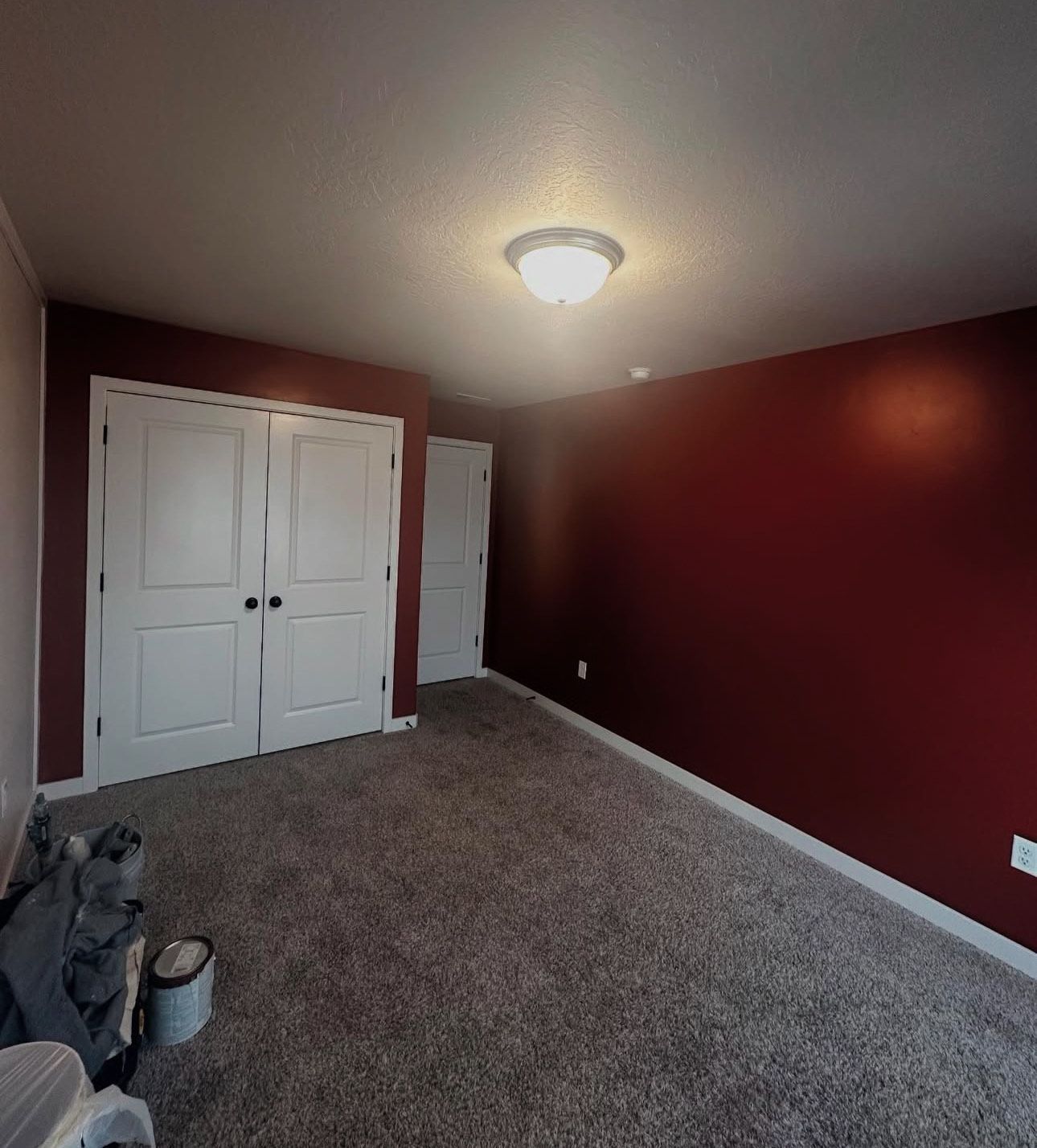 An empty room with red walls and white doors