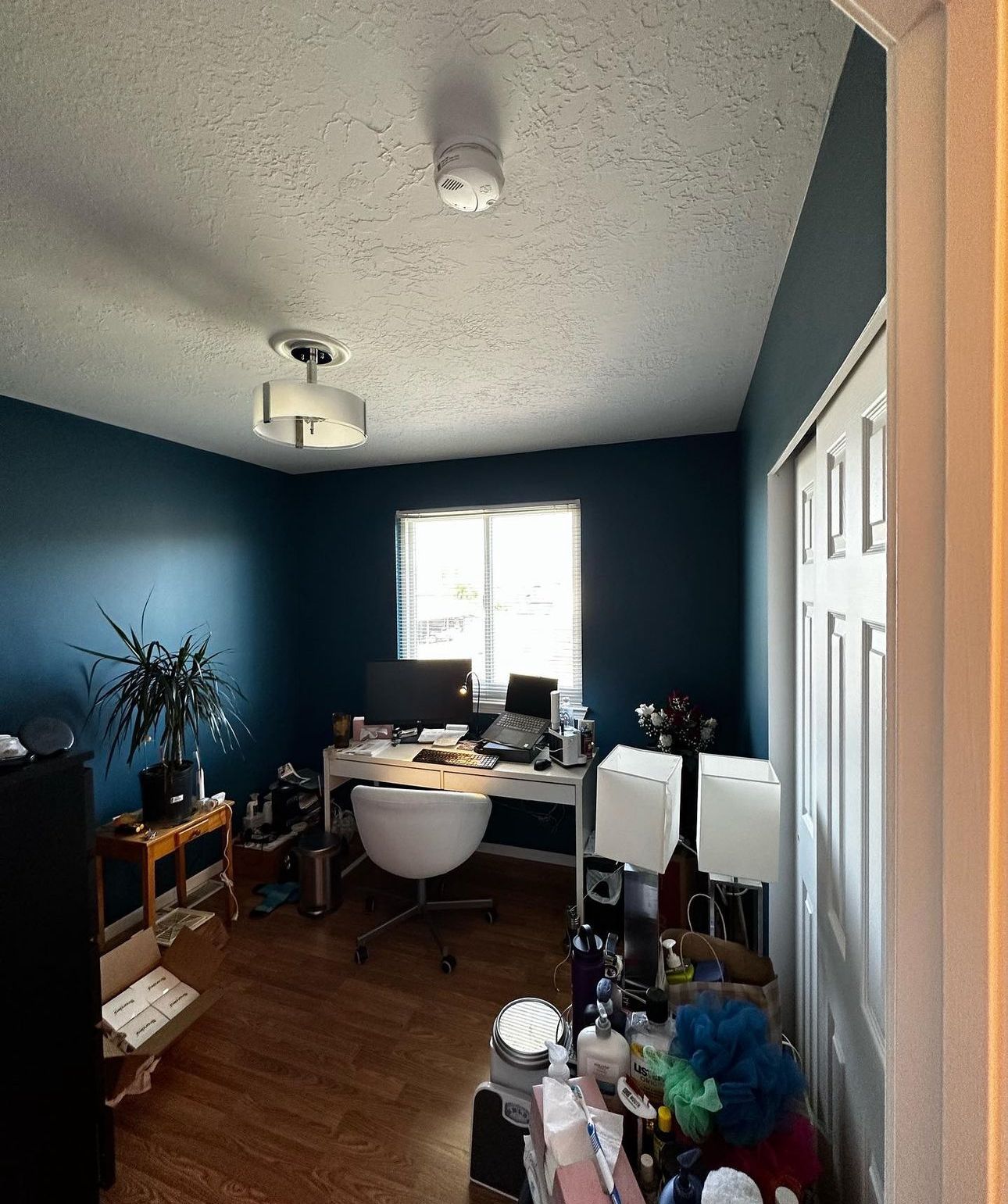 A room with blue walls and a desk with a computer on it