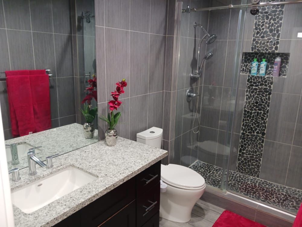 A bathroom with a toilet a sink and a shower