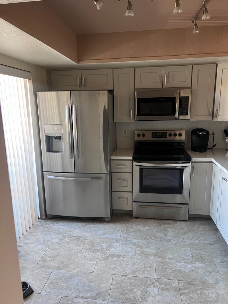 A kitchen with stainless steel appliances and white cabinets