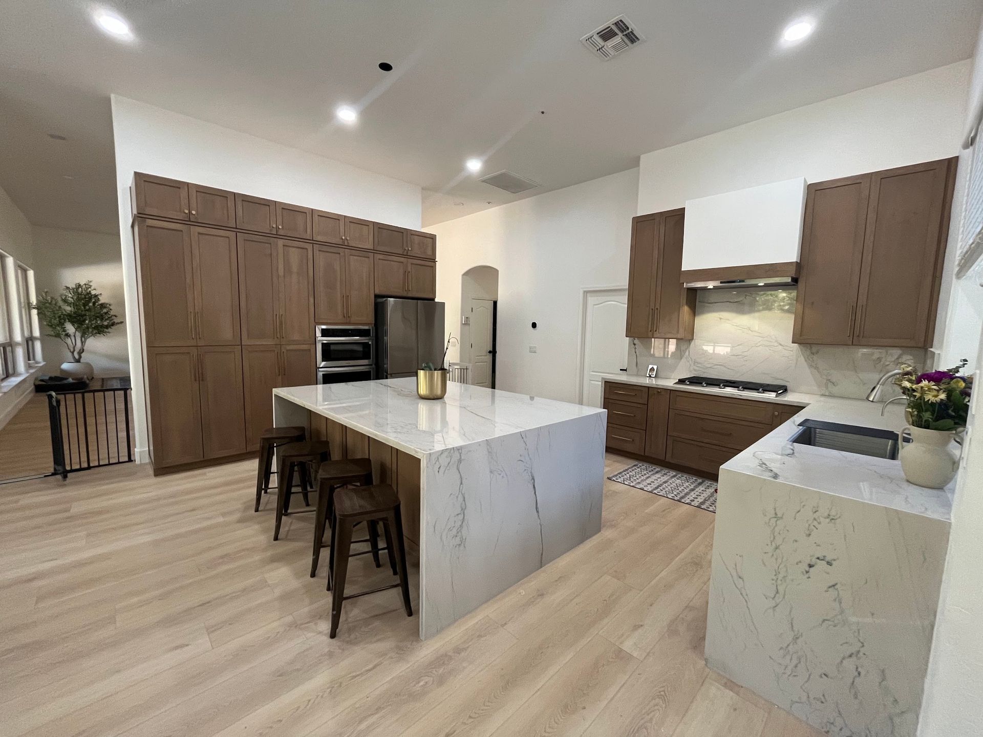 A kitchen with a sink , refrigerator , and microwave.