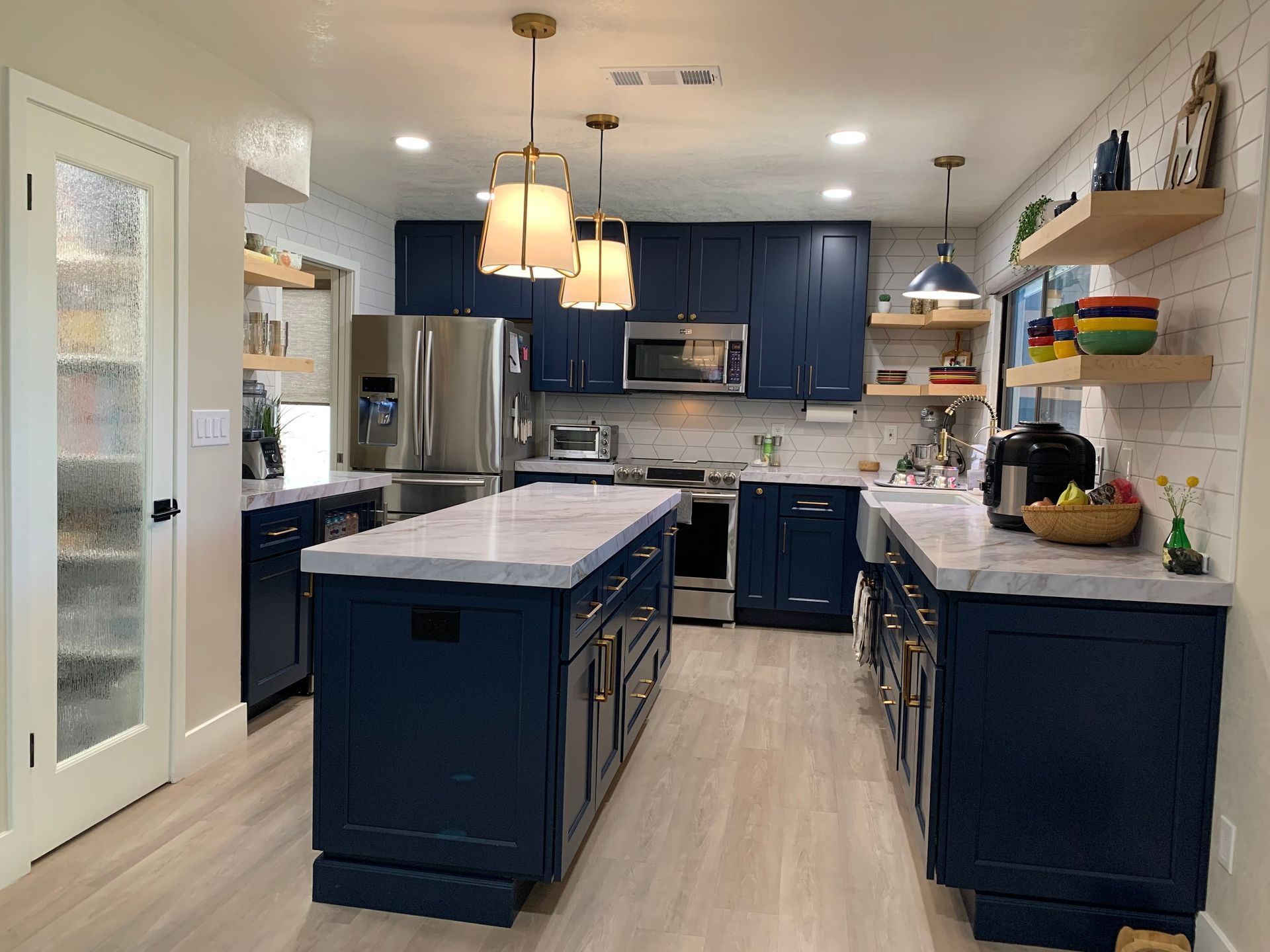 A kitchen with blue cabinets and stainless steel appliances