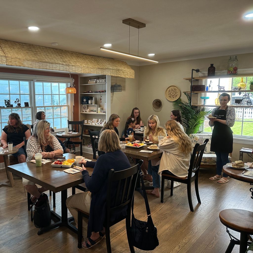 A group of people are sitting at tables in a restaurant eating food.