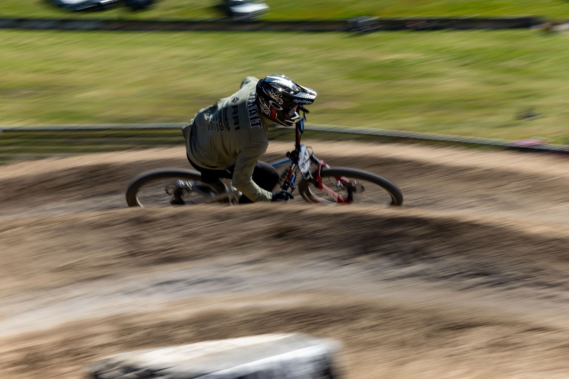 BMX rider in a crash, tumbling on a dirt track. The rider is wearing a helmet and long sleeves.