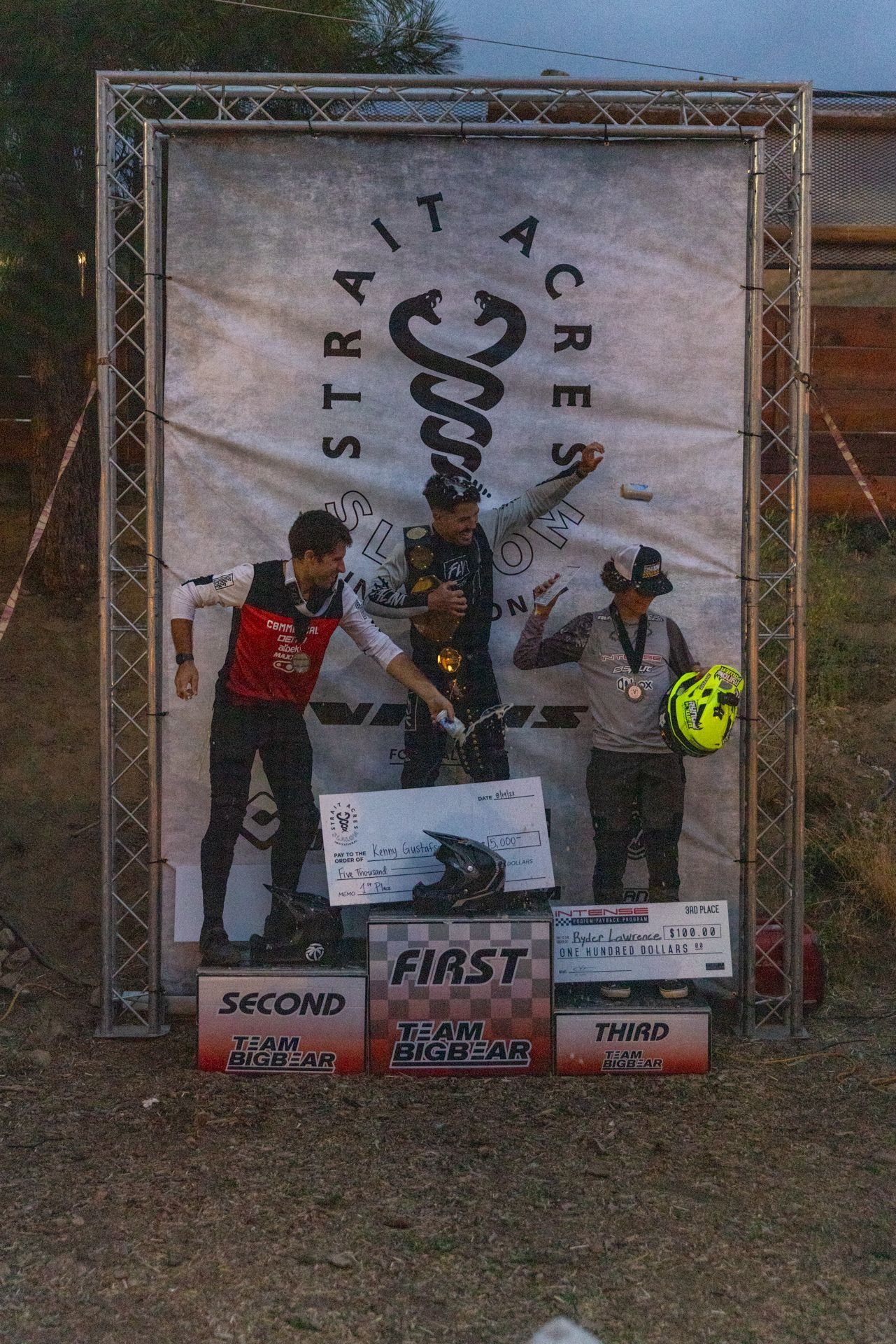 Podium with three people celebrating a race victory at Trail Acres. 