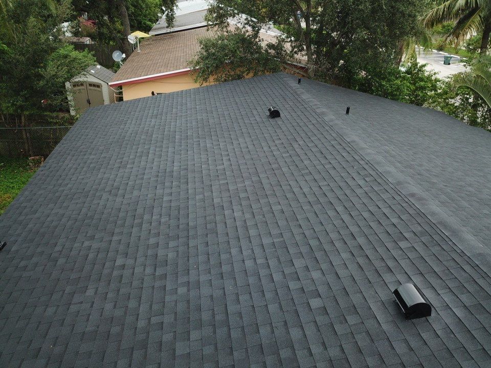 The roof of a house with a black shingle roof