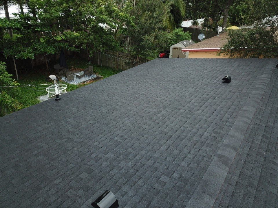 An aerial view of a roof with a few trees in the background.