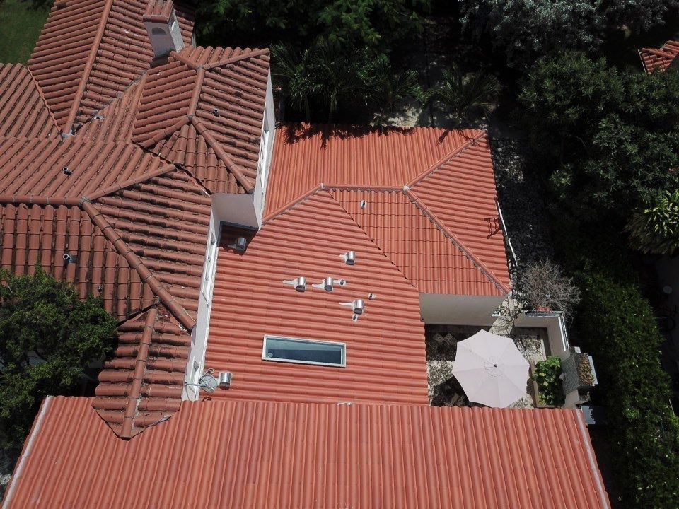 An aerial view of a house with red tile roofs