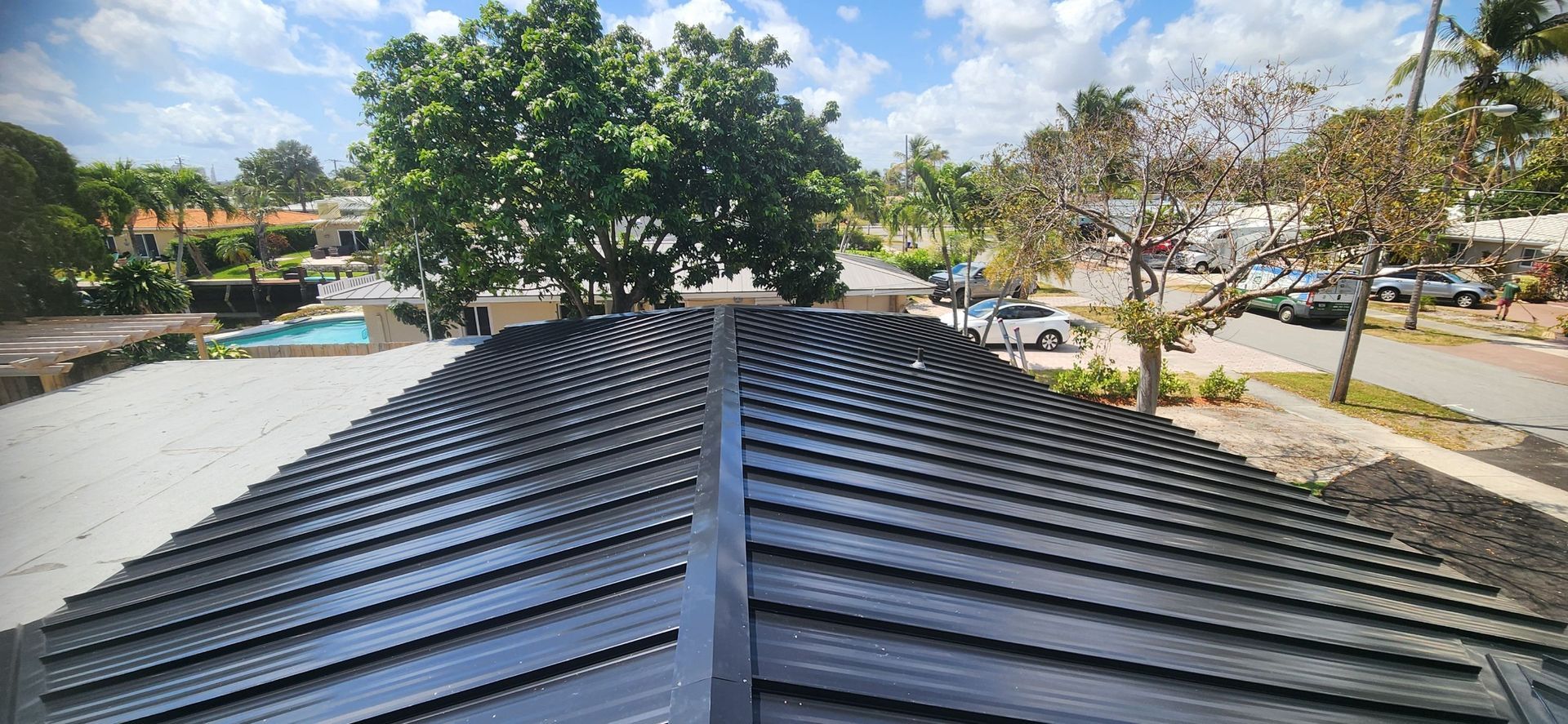 A roof with a lot of shingles on it and a pool in the background.