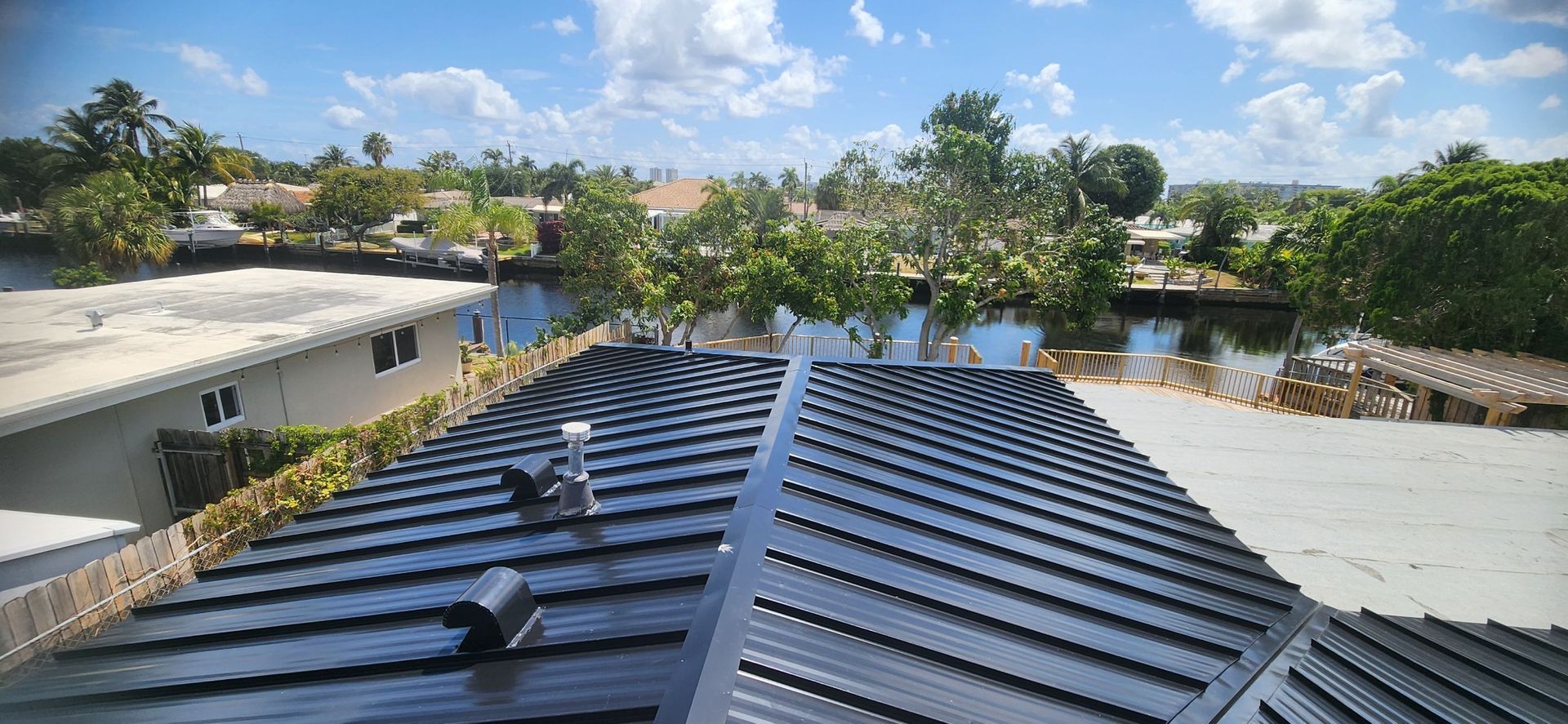 A roof with a lot of solar panels on it and a river in the background.