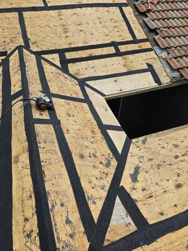 A roof with a hole in it and tape on it