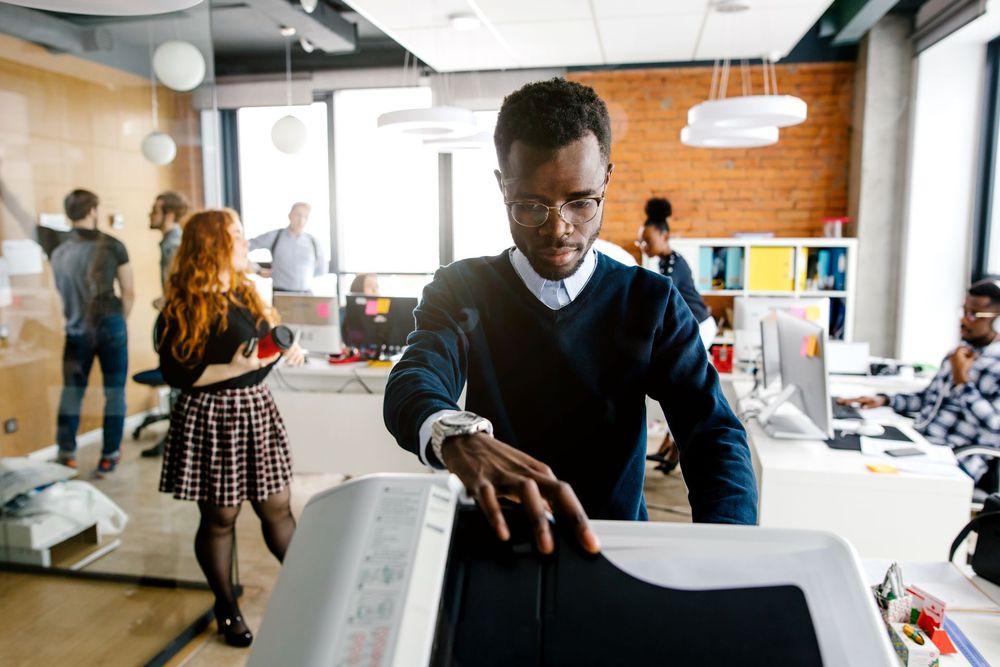 A man is using a copier in an office.
