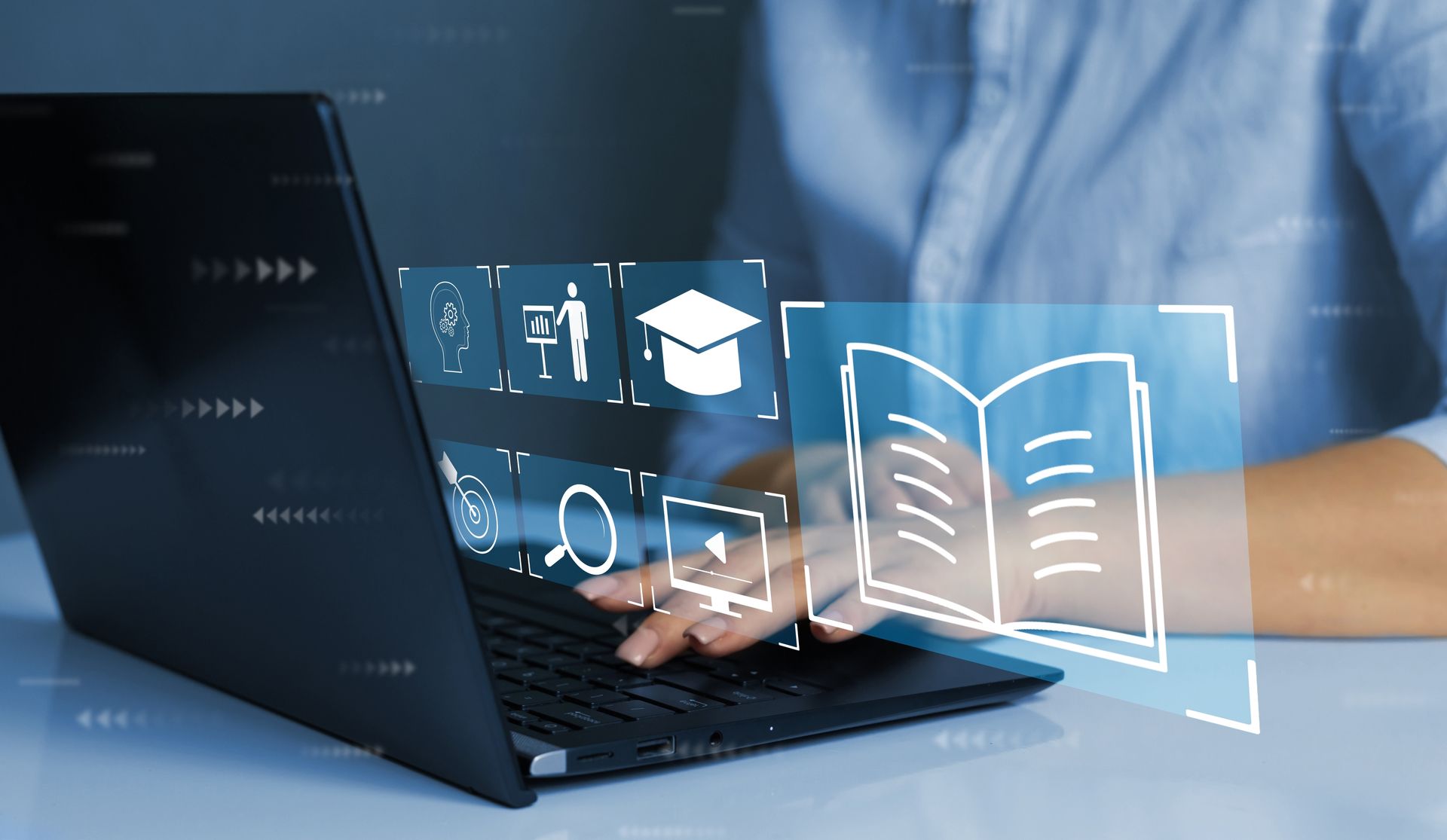 A person is typing on a laptop computer with a book coming out of it.