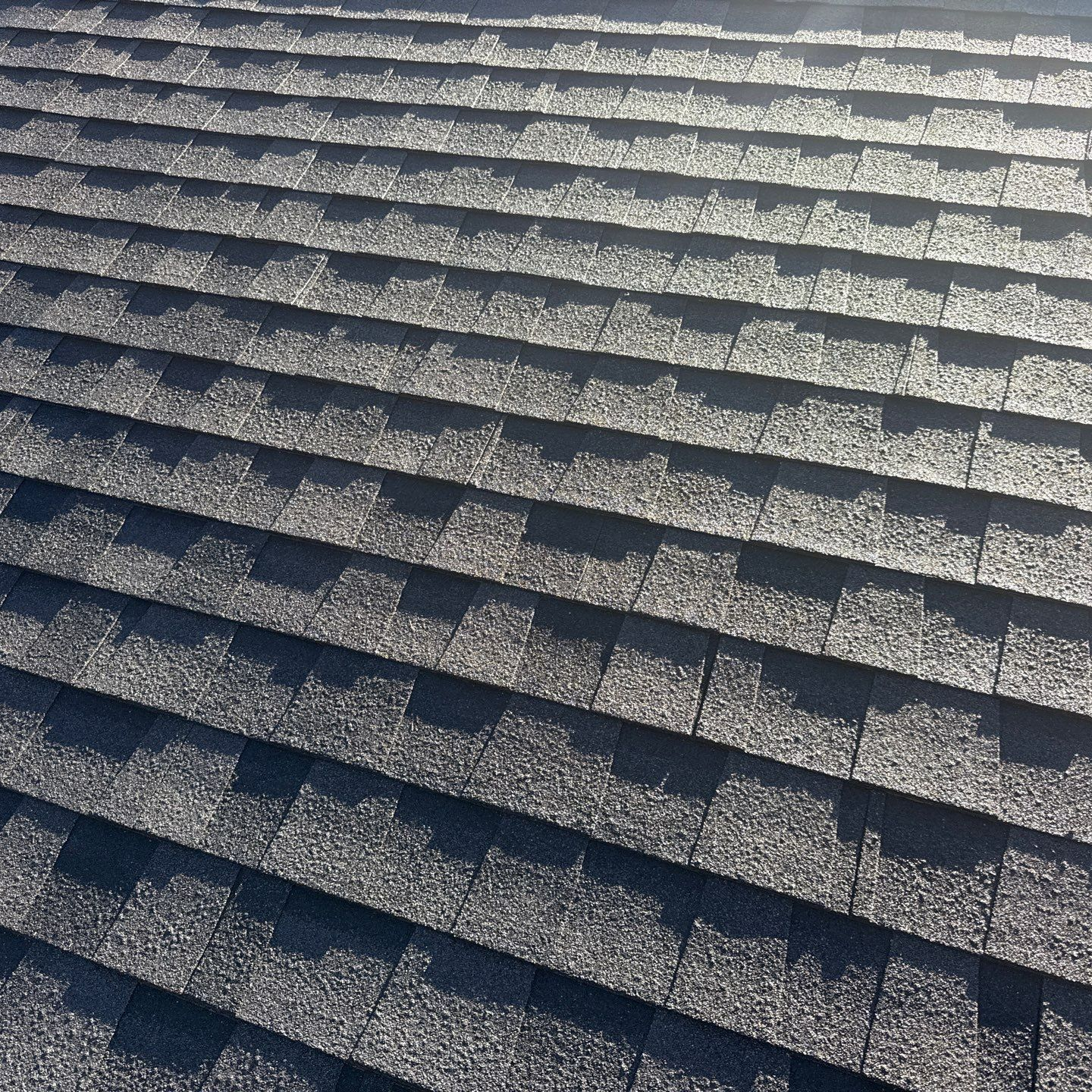 A close up of a roof with shingles and a gutter. A close up of a roof with shingles and a gutter.