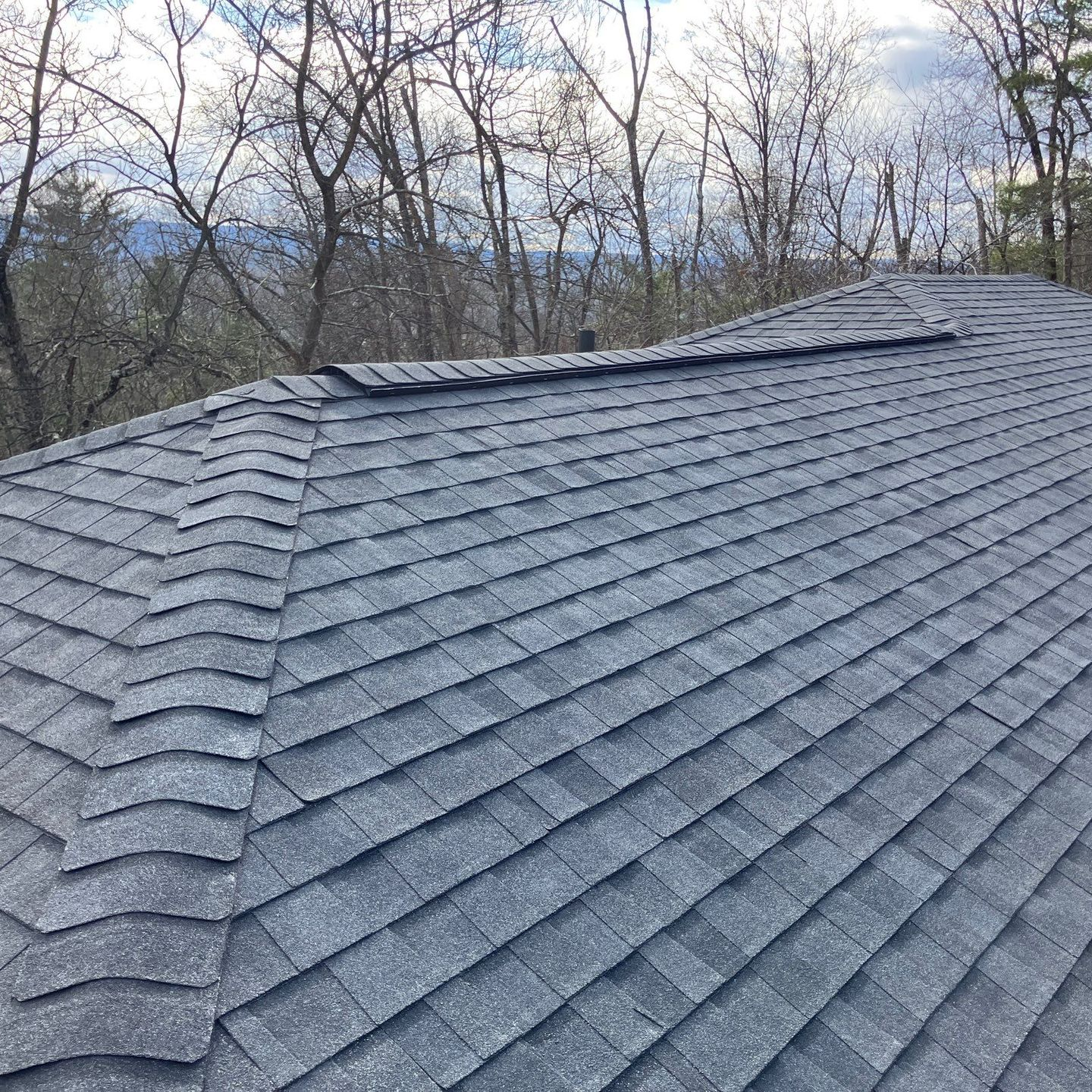 A close up of a roof with shingles and a gutter.