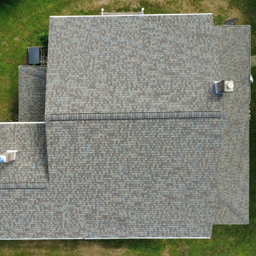 A close up of a roof with shingles and a gutter. A close up of a roof with shingles and a gutter.
