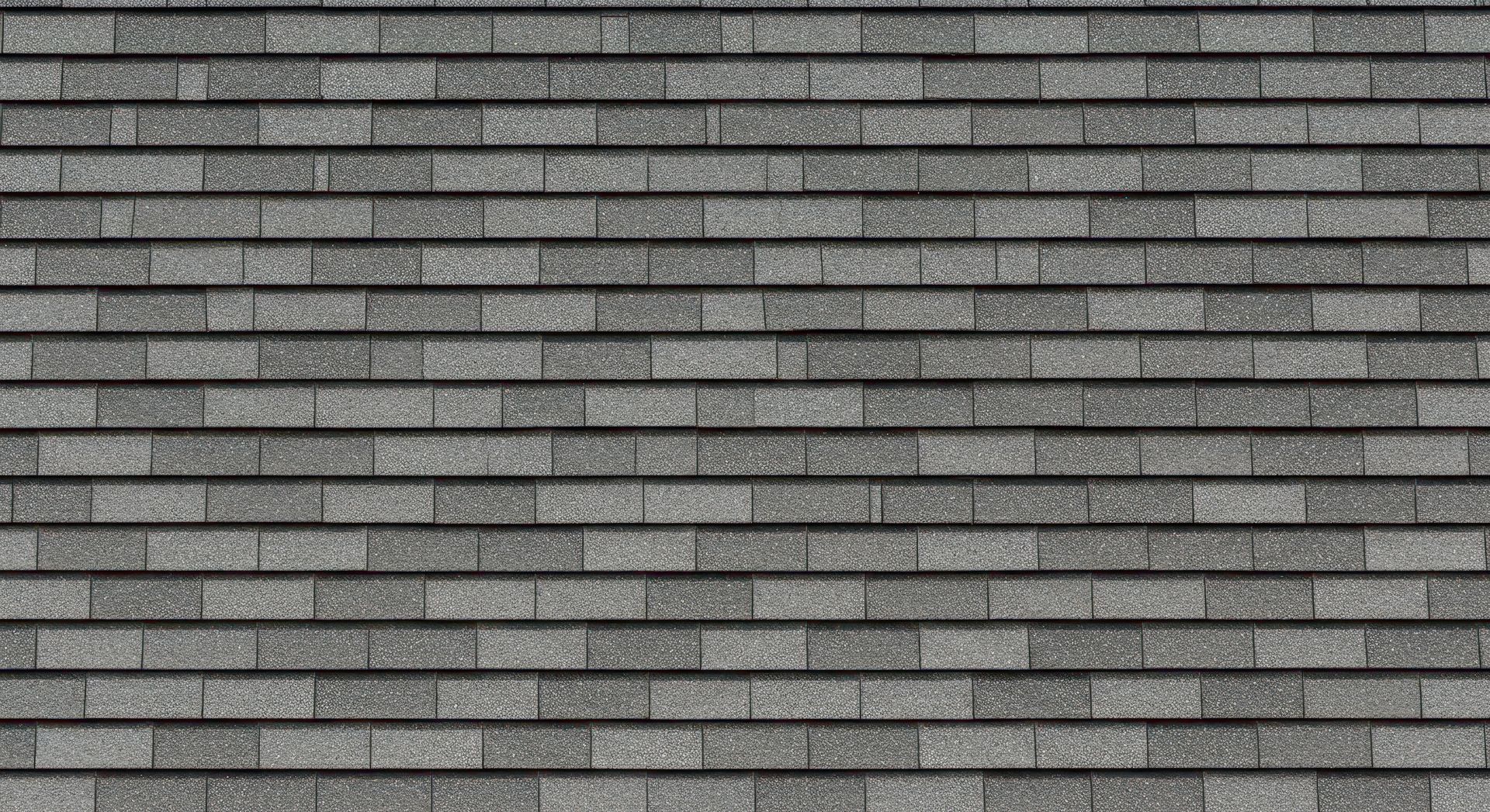 Gray brick wall with horizontal mortar lines and a narrow black border along the bottom