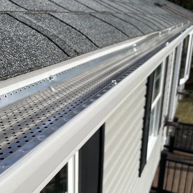 A close up of a gutter on the side of a house