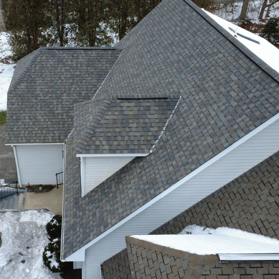 A close up of a roof with shingles and a gutter.