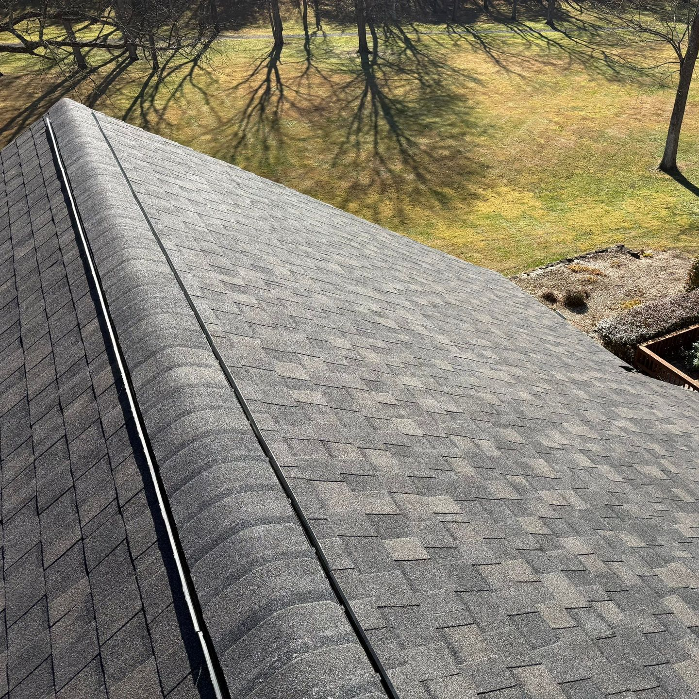 A close up of a roof with shingles and a gutter. A close up of a roof with shingles and a gutter.
