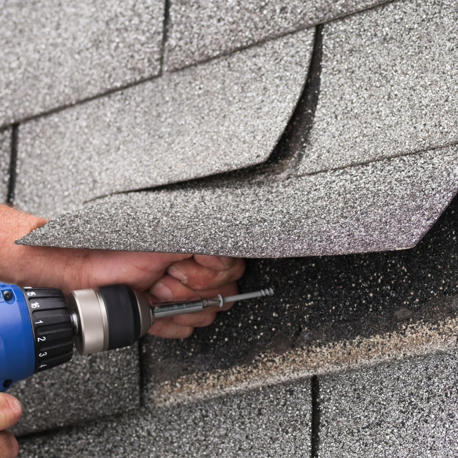 A person is fixing a roof with a drill A person is fixing a roof with a drill
