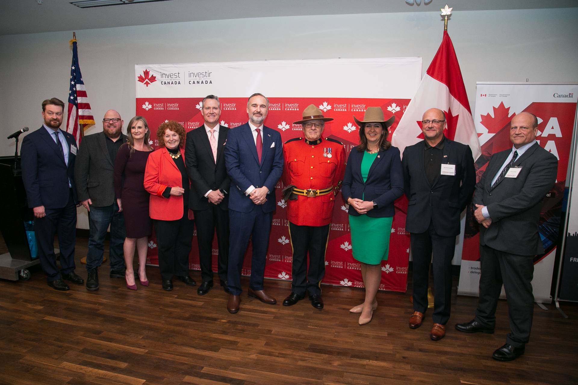 A group of people are posing for a picture in front of a canadian flag.