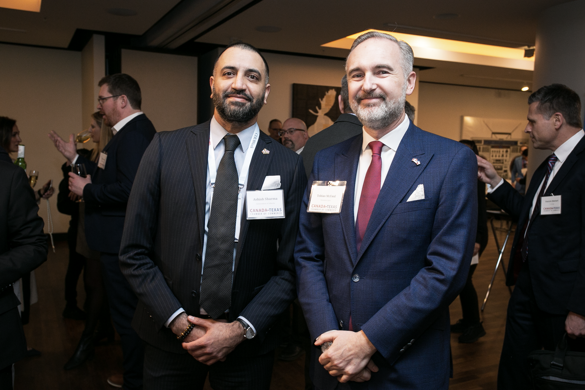 Two men in suits and ties are standing next to each other in a room.