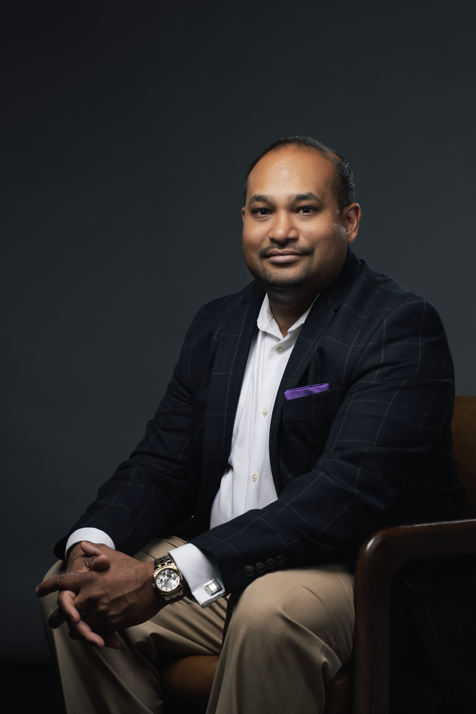 A man in a suit and tie is sitting in a chair.