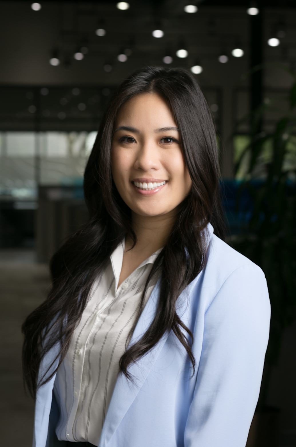 A woman in a blue jacket and white shirt is smiling for the camera.