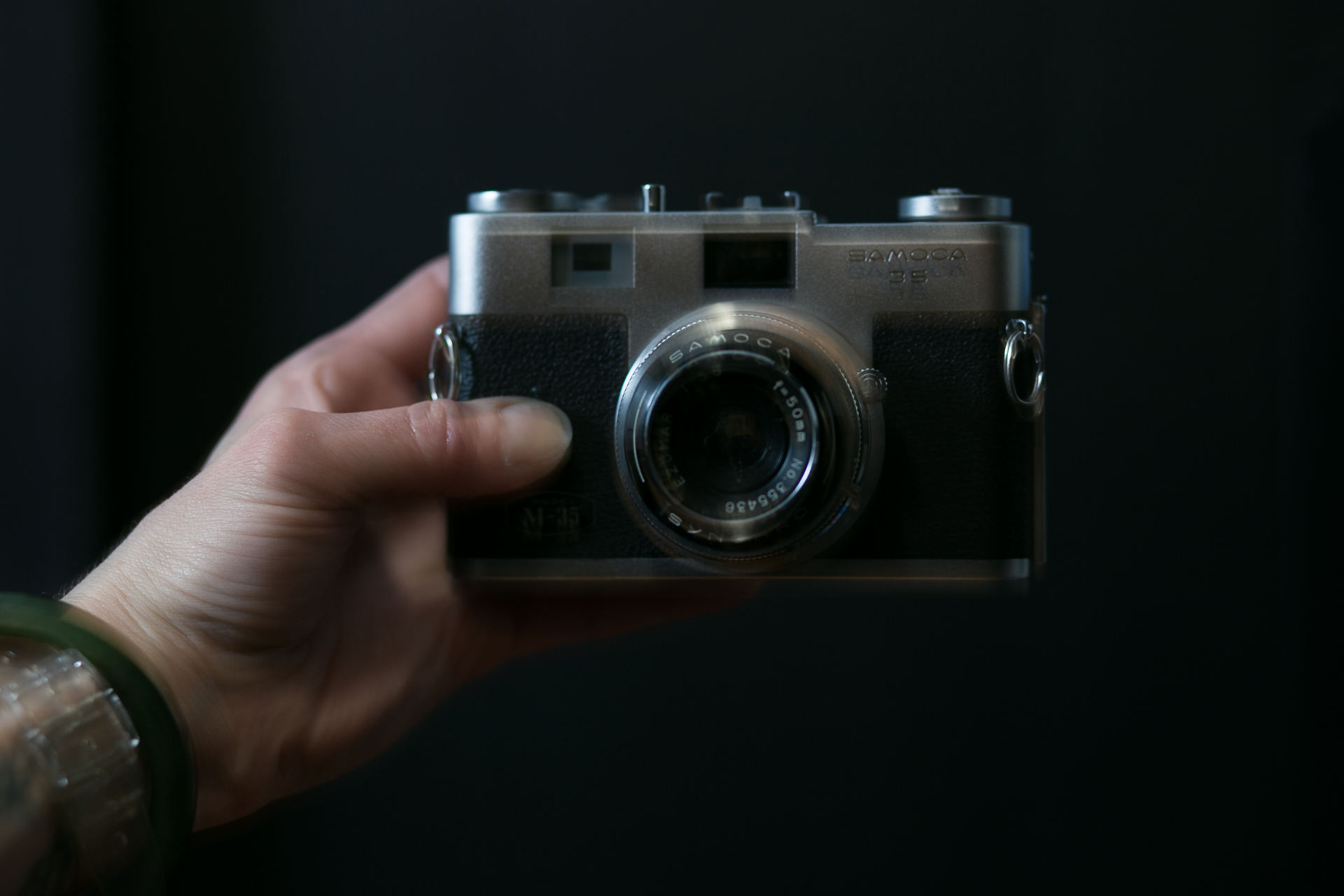 A person is holding an old camera in their hand.