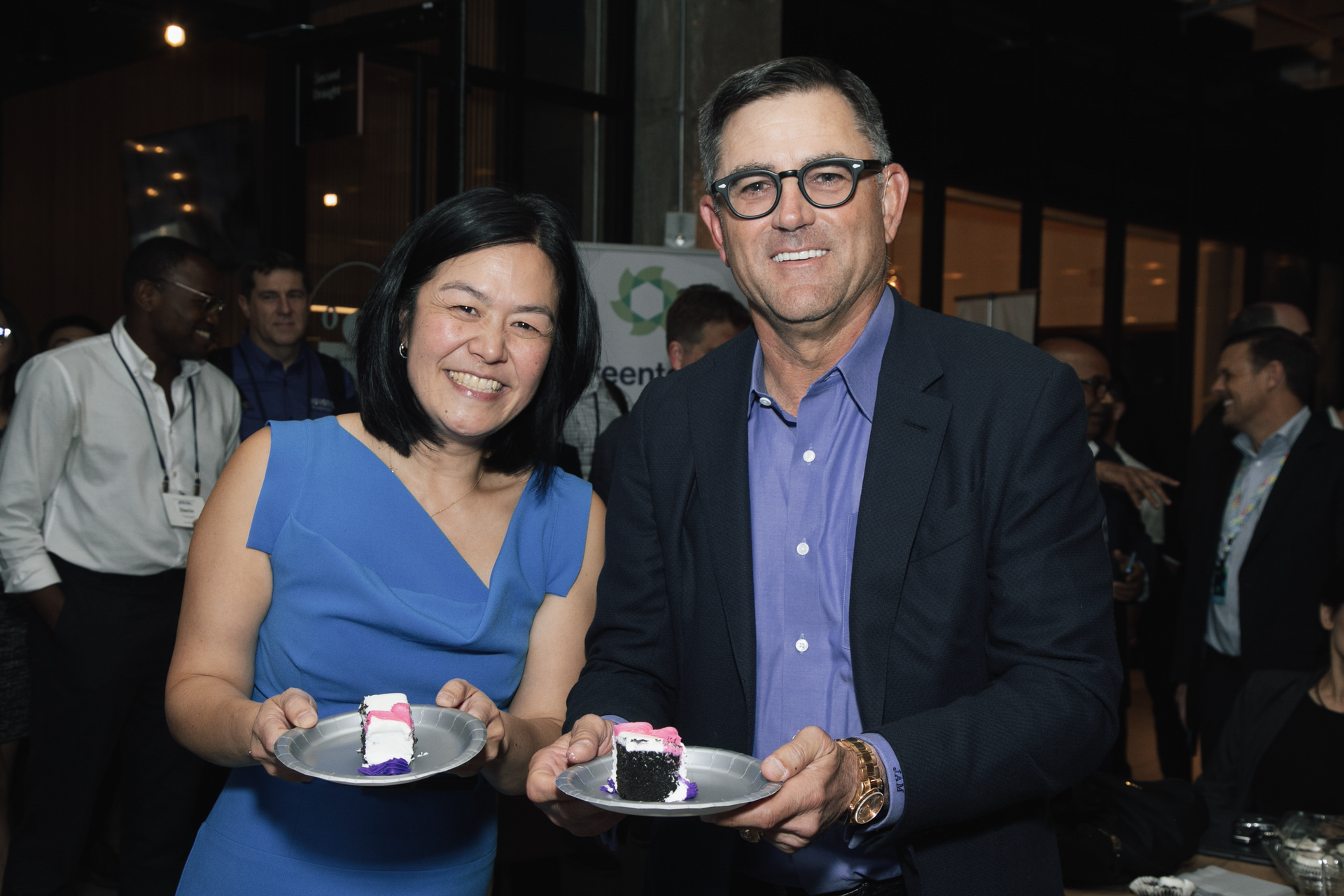 A man and a woman are holding plates of food in their hands.