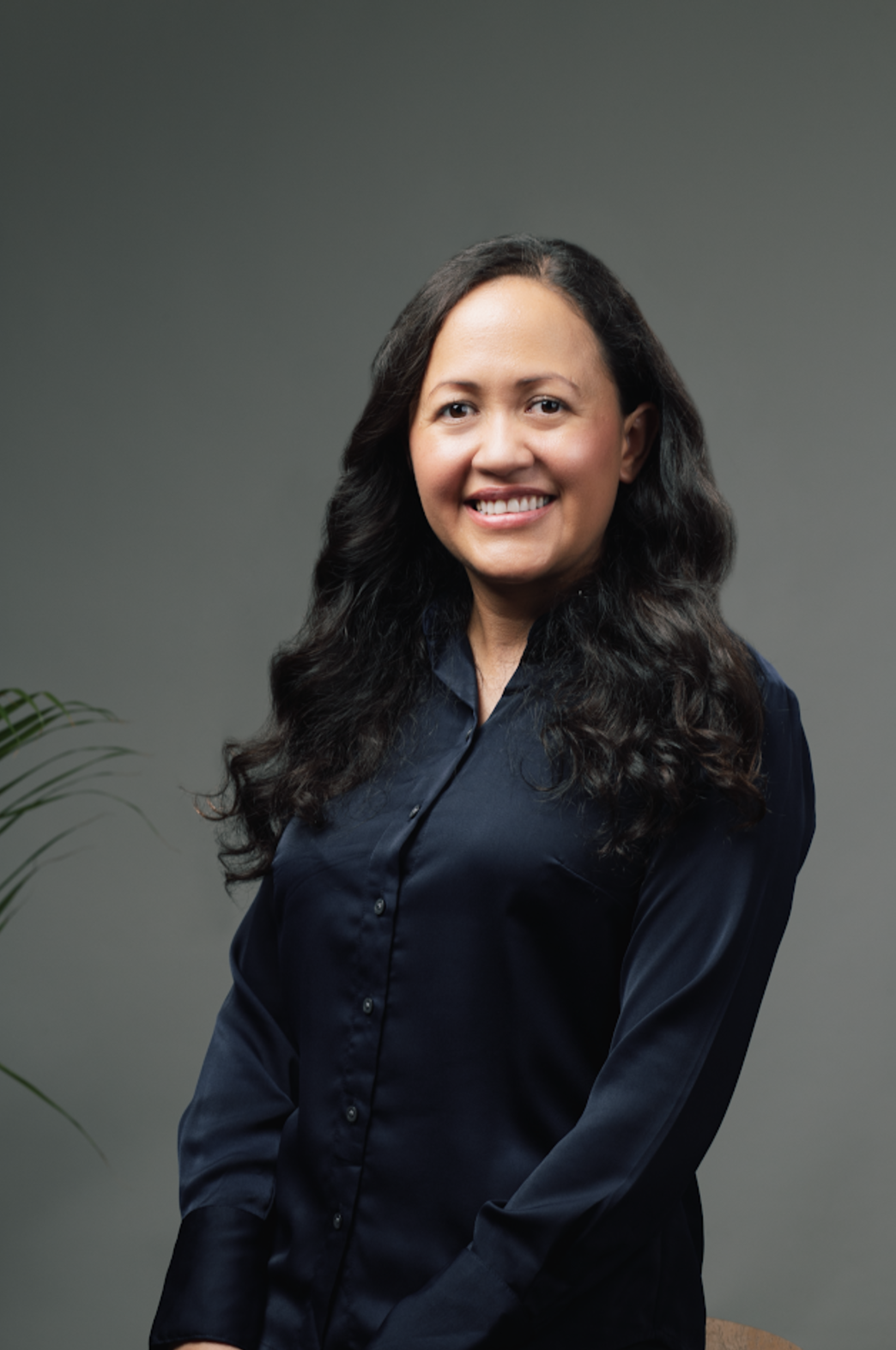 A woman in a black shirt is smiling for the camera.