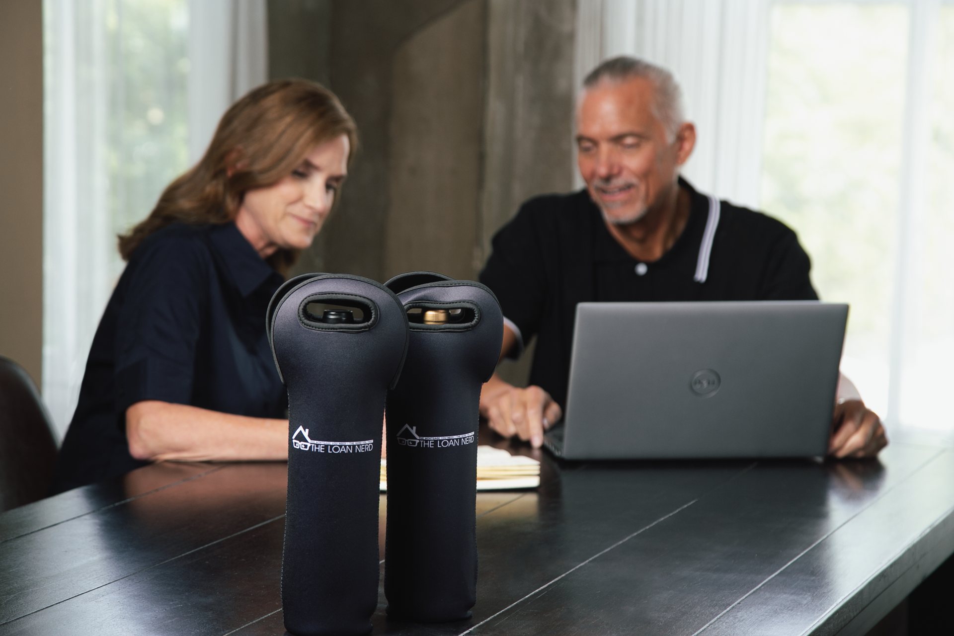 Two women are posing for a picture in front of a photo booth.