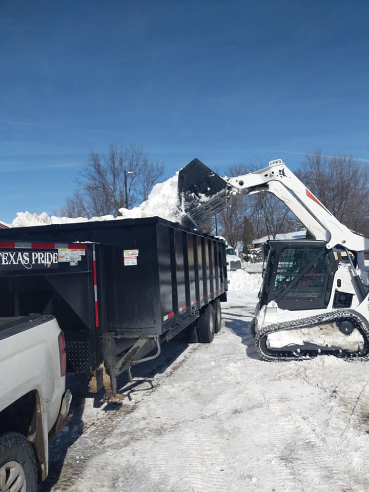 Snow Clearing — Tractor Putting Snow on a Truck in Minneapolis, MN