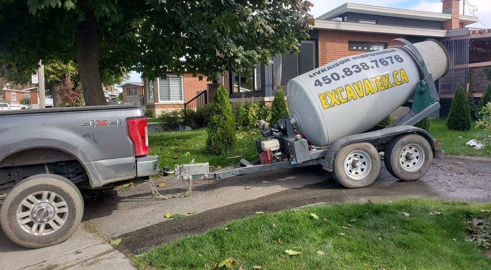 Un camion remorque une bétonnière sur une remorque.