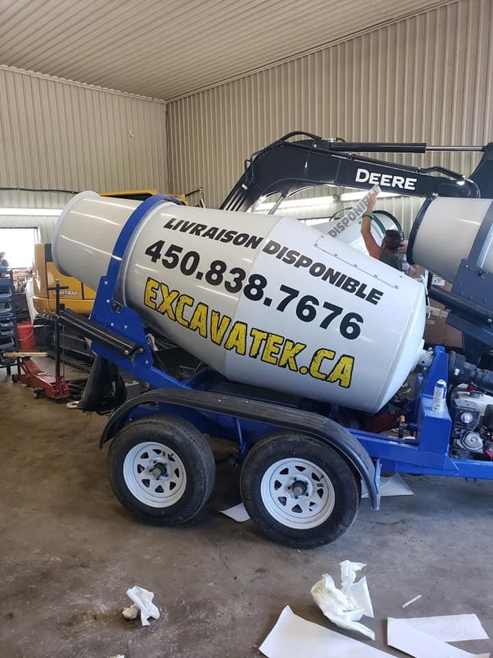Une bétonnière est sur une remorque dans un garage.