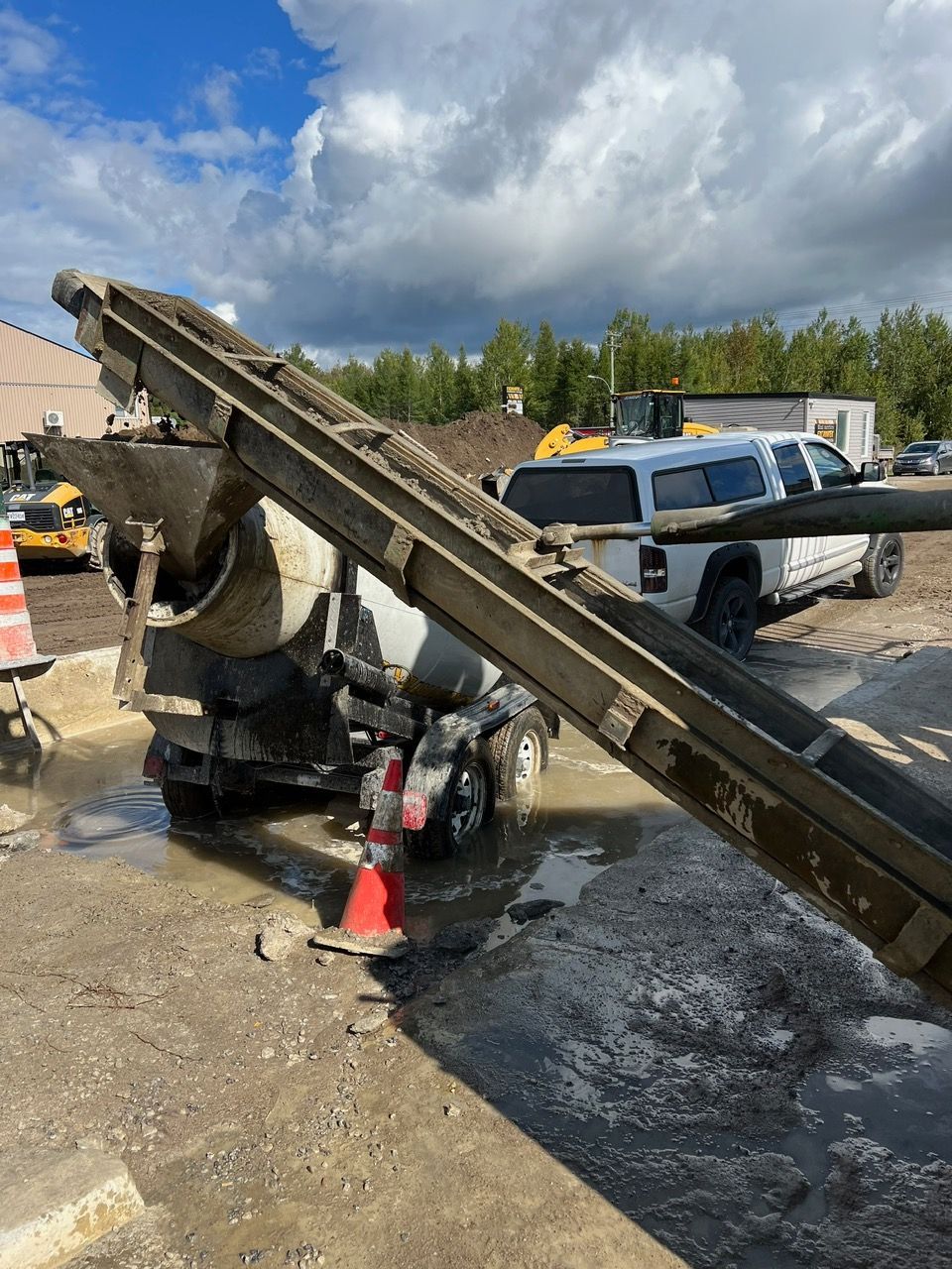 Une bétonnière est chargée de béton sur un chantier de construction.