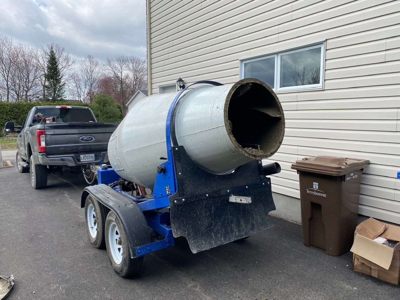 Un camion remorque une bétonnière sur une remorque.